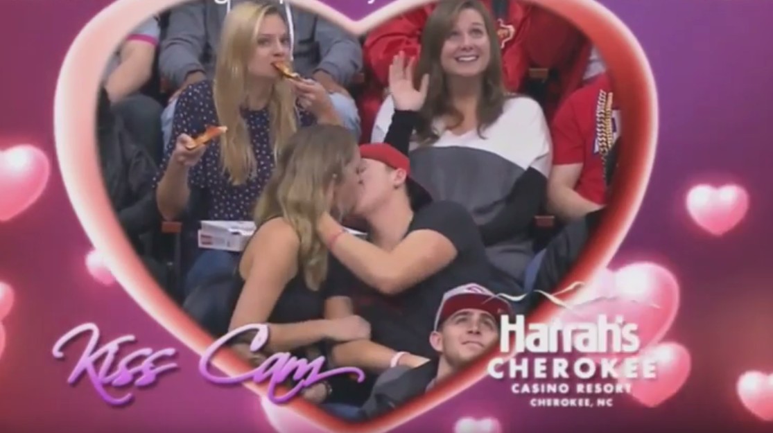 Girl double fists pizza on kiss-cam and becomes the hero we all deserve